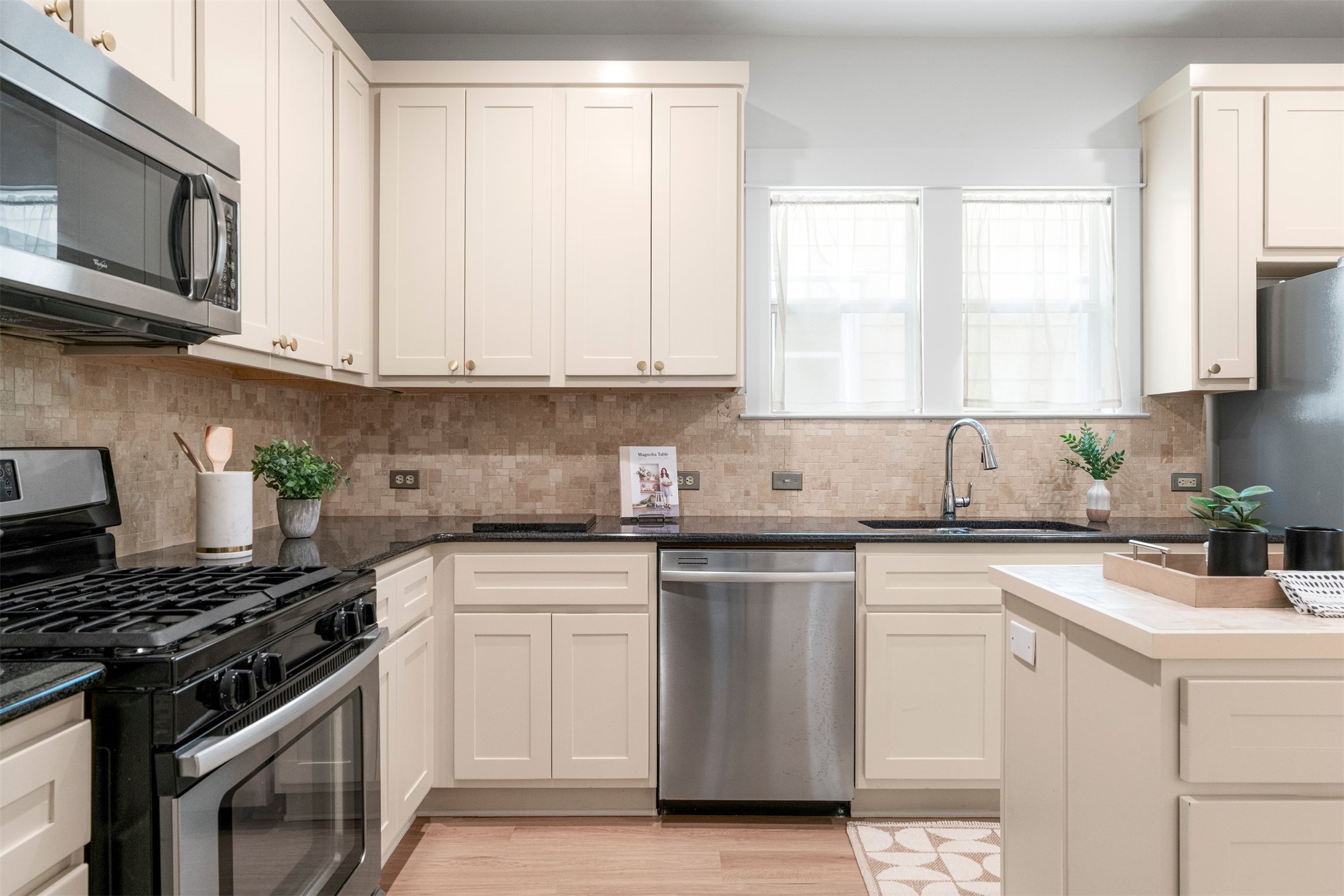 4216 Threadgill Street Austin, TX 78723 - Photo 23 of 40 a kitchen with white cabinets appliances and a window
