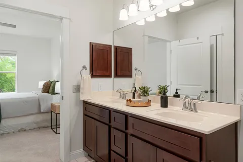 a bathroom with a sink a large mirror and a light fixture