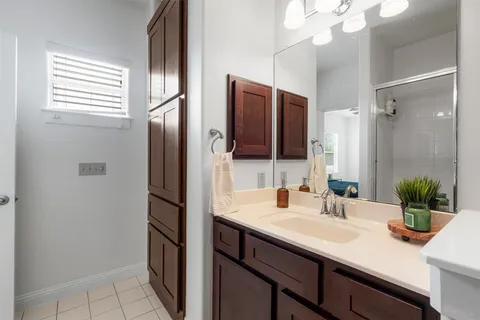 a bathroom with a sink a potted plant and a mirror
