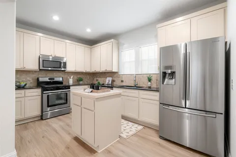a kitchen with cabinets stainless steel appliances and window