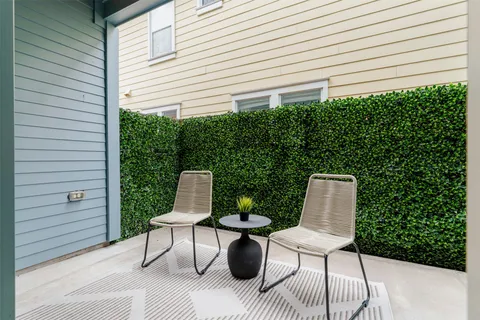 a view of a chairs and table in back yard of a house
