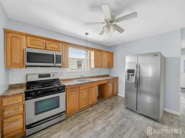 a kitchen with granite countertop a refrigerator stove top oven and sink