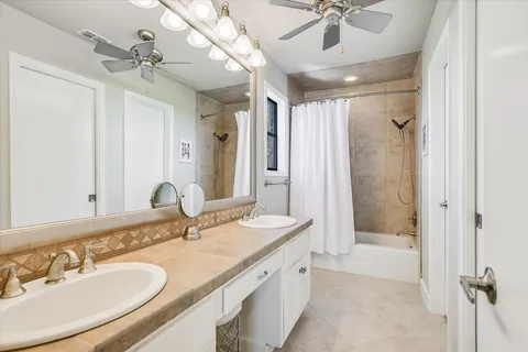 a bathroom with a granite countertop sink mirror bathtub and shower