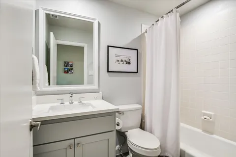 a bathroom with a sink vanity mirror and toilet