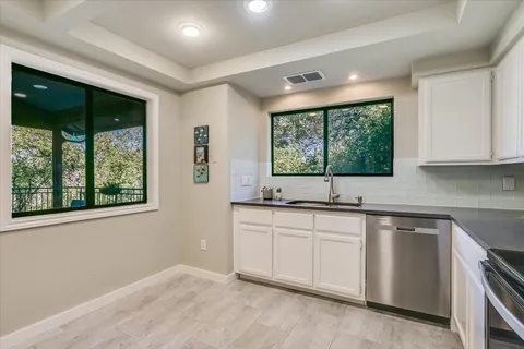 a kitchen with a sink windows and cabinets
