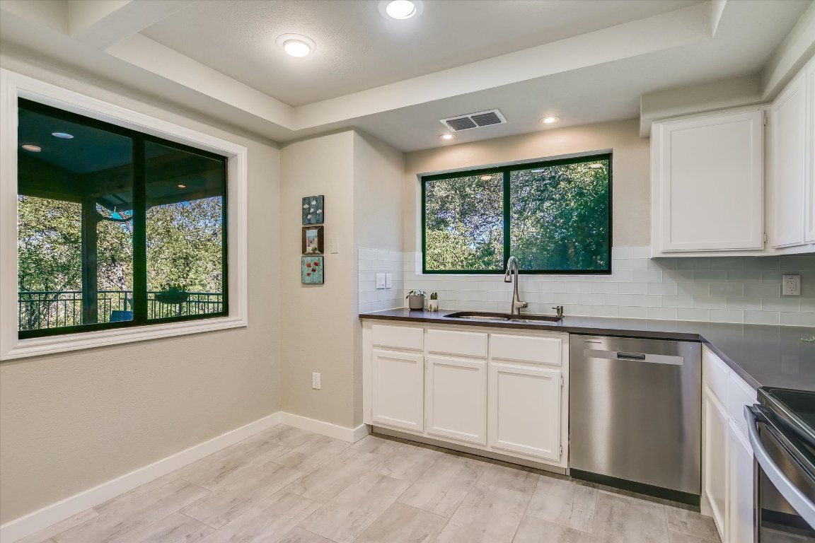8200 Neely Drive, Unit 206 Austin, TX 78759 - Photo 9 of 26 a kitchen with a sink windows and cabinets