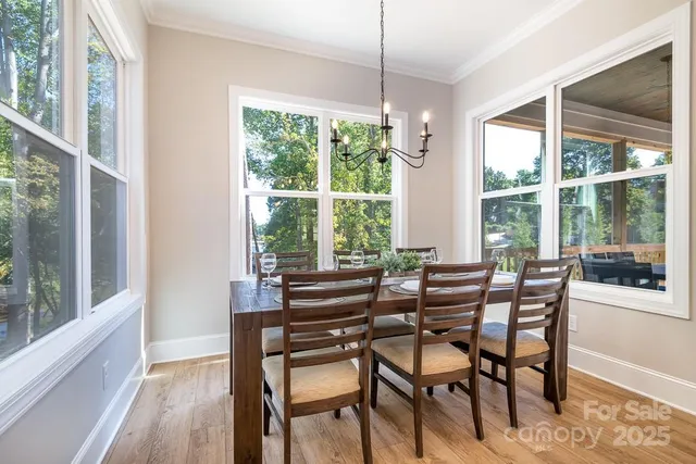 a dining room with furniture large windows and wooden floor