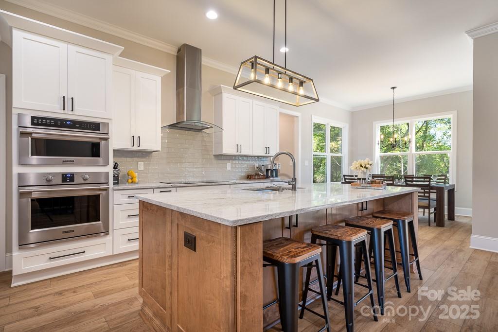 787 Morrison Farm Road Troutman, NC 28166 - Photo 5 of 24 a open kitchen with stainless steel appliances granite countertop a stove and a wooden floor