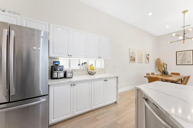 a kitchen with stainless steel appliances kitchen island granite countertop a table and chairs in it