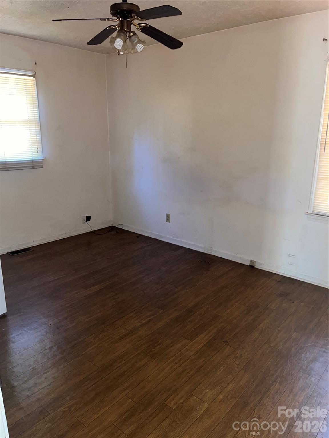 6957 Vintage Road Lilesville, NC 28091 - Photo 7 of 10 an empty room with wooden floor fan and windows