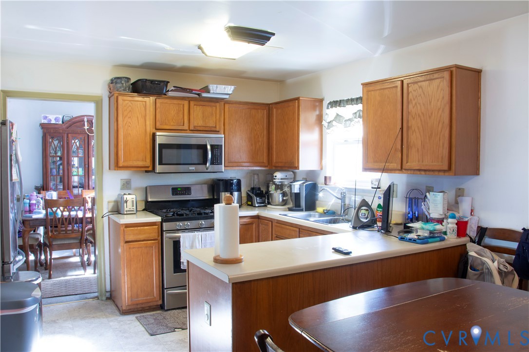 5781 Swanson Road Richmond, VA 23225 - Photo 4 of 16 Kitchen featuring brown cabinets, light countertop