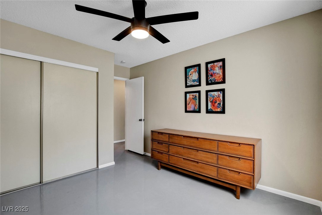 3215 Mountain Spring Road Las Vegas, NV 89146 - Photo 25 of 42 Bedroom featuring concrete floors, a closet, ceiling fan, and a textured ceiling