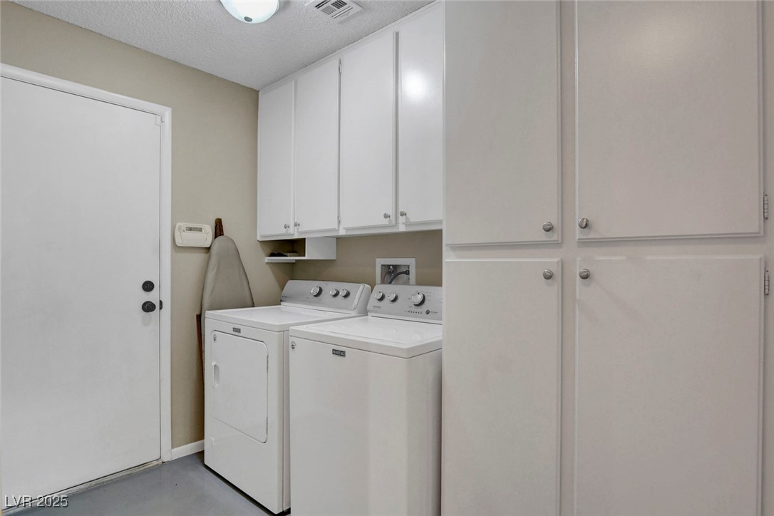 3215 Mountain Spring Road Las Vegas, NV 89146 - Photo 34 of 42 Laundry area with cabinet space, finished concrete flooring, a textured ceiling, and washing machine and dryer