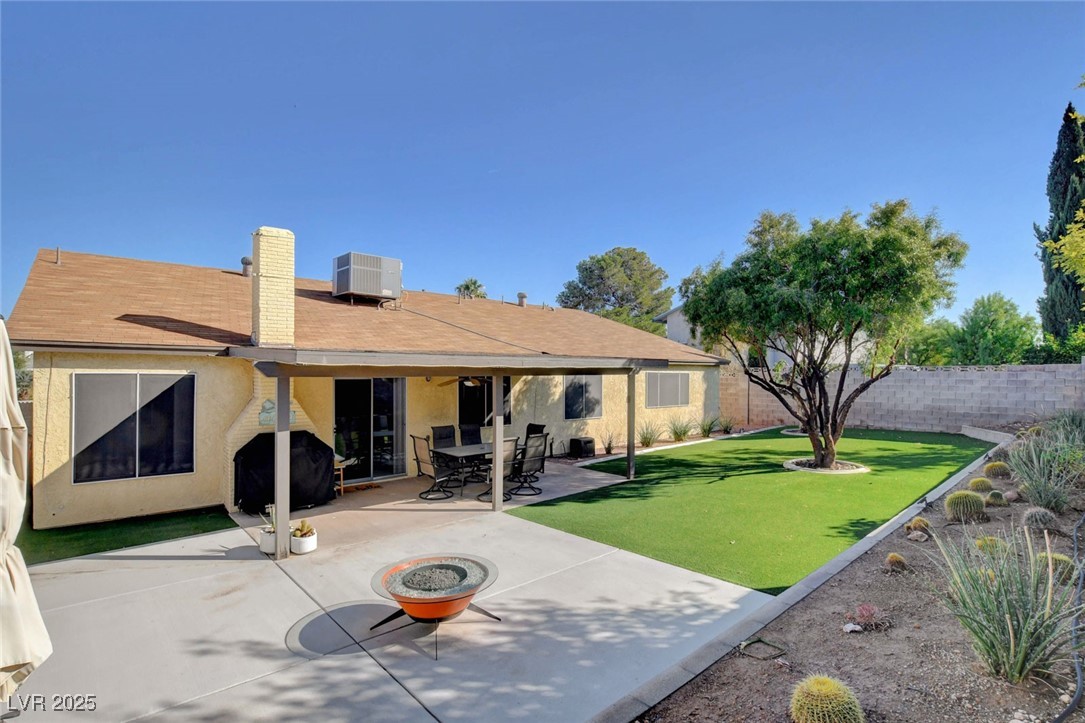 3215 Mountain Spring Road Las Vegas, NV 89146 - Photo 36 of 42 Rear view of house featuring a patio area, a fenced backyard, stucco siding, a fire pit, and a chimney