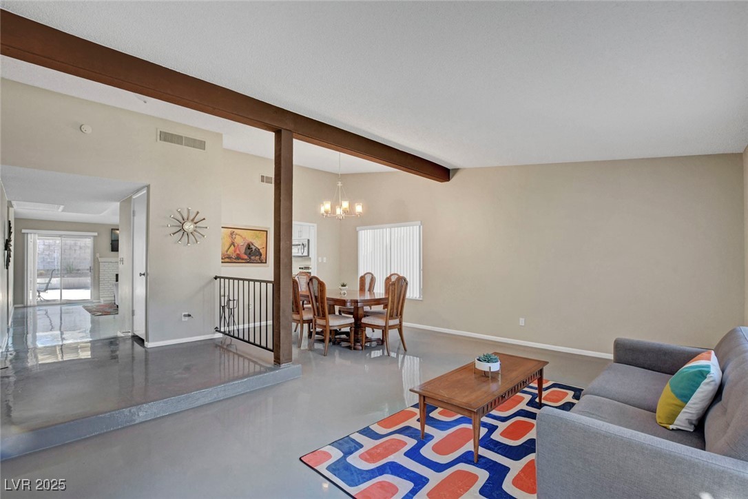 3215 Mountain Spring Road Las Vegas, NV 89146 - Photo 7 of 42 Living area with concrete flooring, beam ceiling, and a chandelier