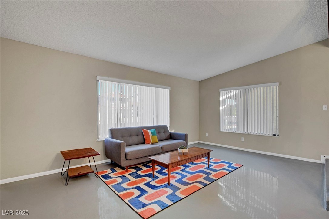 3215 Mountain Spring Road Las Vegas, NV 89146 - Photo 8 of 42 Living area with vaulted ceiling, plenty of natural light, a textured ceiling, and concrete flooring
