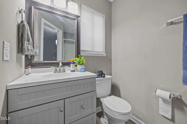 a bathroom with a sink mirror vanity and toilet