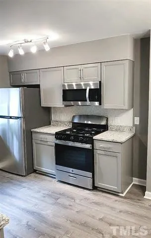 a kitchen with a stove and a refrigerator