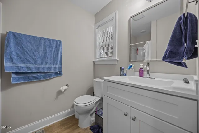 a bathroom with a toilet a sink and mirror