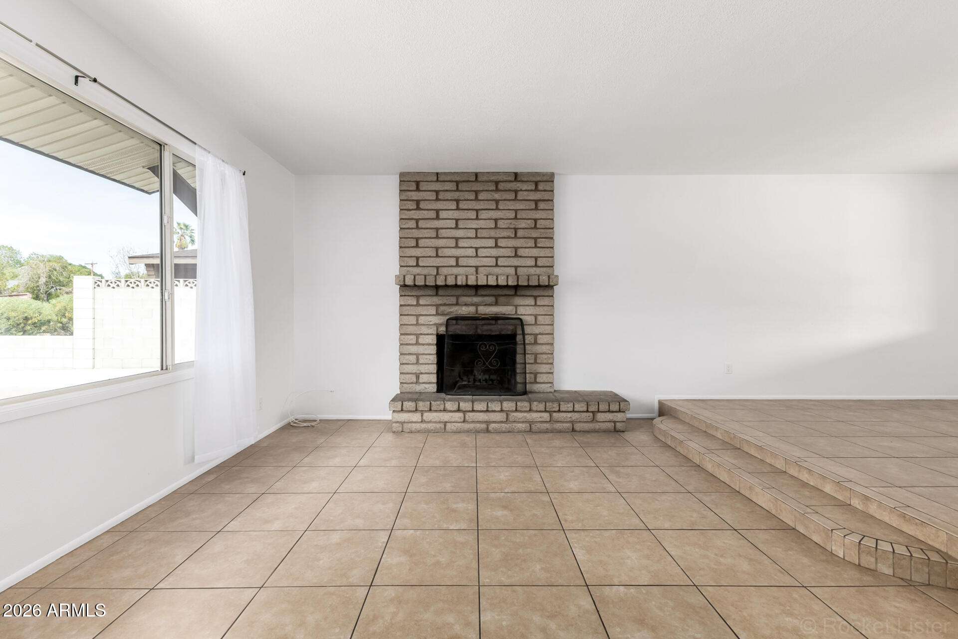 4617 South Grandview Avenue Tempe, AZ 85282 - Photo 6 of 31 a view of an empty room with a fireplace and a window
