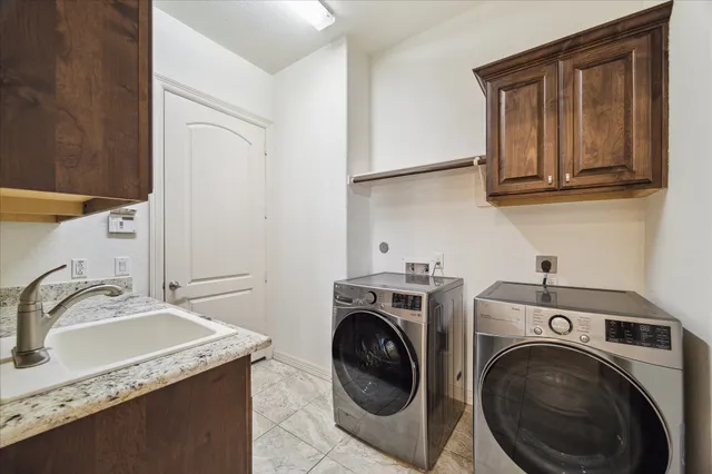 a utility room with sink dryer and washer