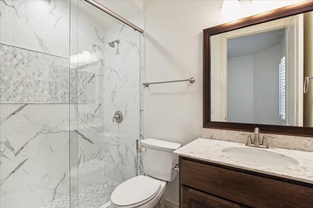 a bathroom with a granite countertop sink toilet and shower
