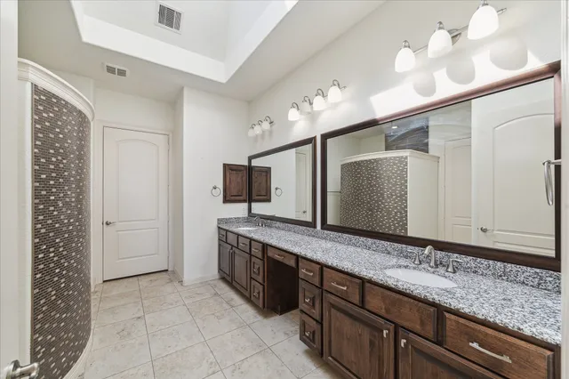 a bathroom with a double vanity sink and a mirror