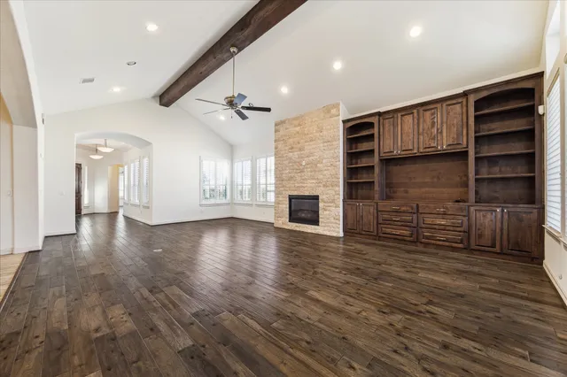a view of an empty room with a fireplace and a window