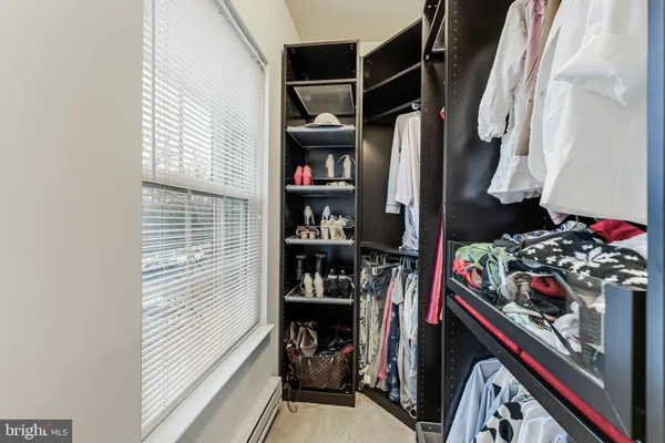 a view of walk in closet with clothes and shoes
