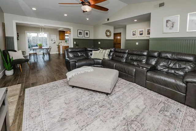 a living room with furniture and a wooden floor