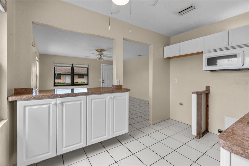 27242 Sunnybrook Road Punta Gorda, FL 33983 - Photo 11 of 36 a kitchen with white cabinets and sink