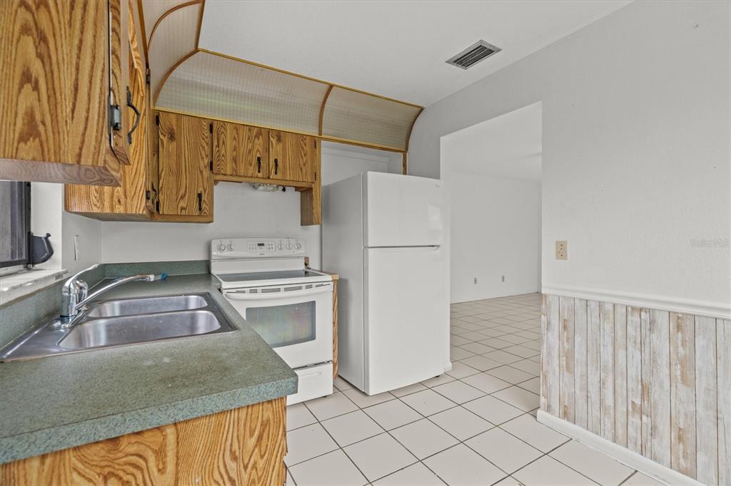 27242 Sunnybrook Road Punta Gorda, FL 33983 - Photo 24 of 36 a kitchen with a refrigerator and a sink