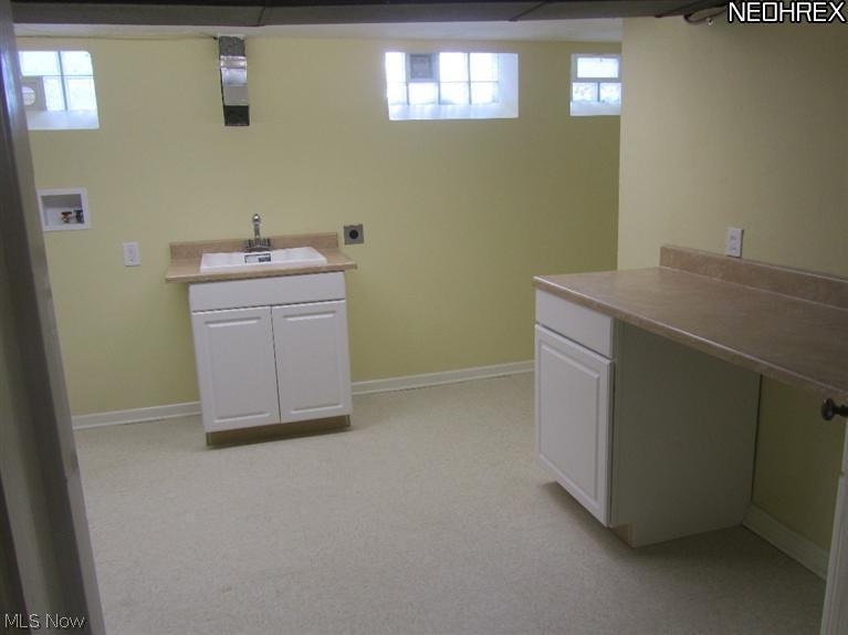 2610 Kerwick Road Cleveland, OH 44118 - Photo 23 of 23 Bright remodeled laundry room with sink, cabinet storage and lots of counter top for sorting and folding.