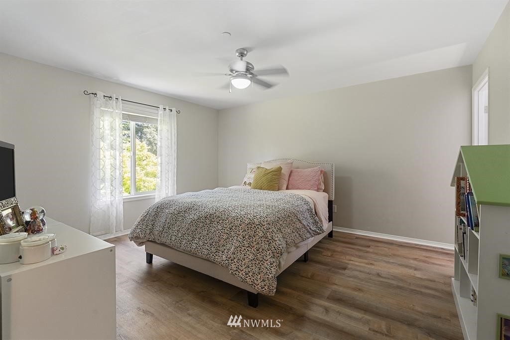 3103 Walker Road DuPont, WA 98327 - Photo 14 of 25 a bedroom with a bed and a dresser with wooden floor
