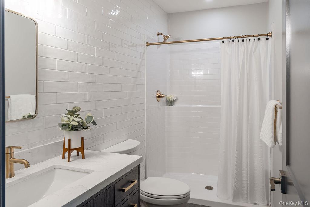 4 Icehouse Drive Saugerties, NY 12477 - Photo 26 of 34 Lower Level Full bath with tile walls, a shower stall, and vanity