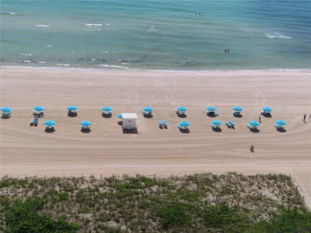 a view of ocean with lots of car parked
