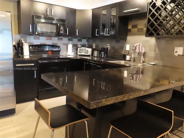 a kitchen with stainless steel appliances kitchen island granite countertop a sink and cabinets