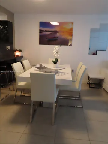 a living room with furniture and a dining table with kitchen view