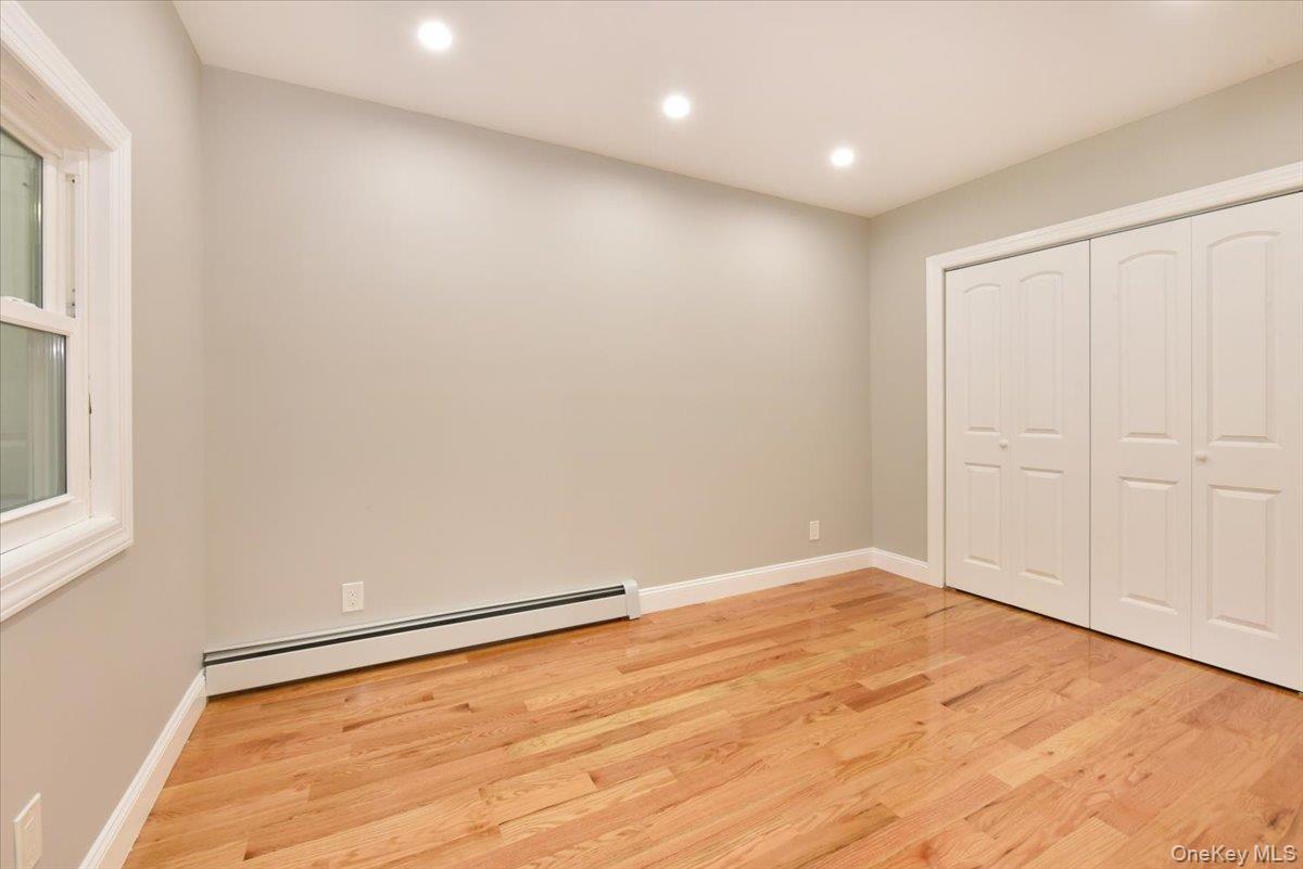 87 Dunlop Road Huntington, NY 11743 - Photo 15 of 31 an empty room with wooden floor and windows