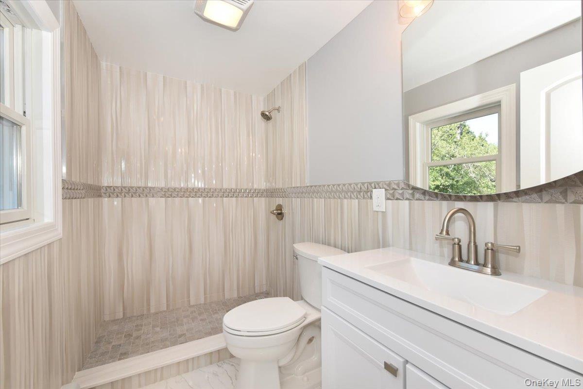 87 Dunlop Road Huntington, NY 11743 - Photo 20 of 31 a bathroom with a sink a toilet and shower