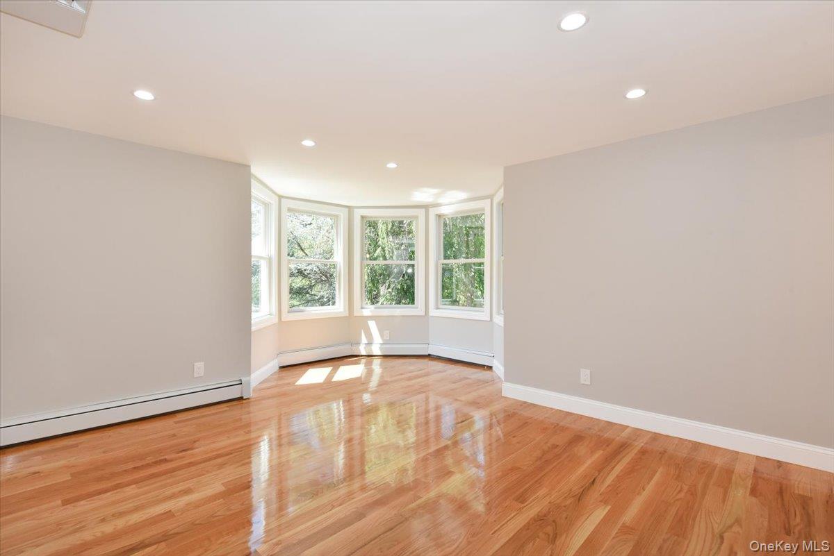 87 Dunlop Road Huntington, NY 11743 - Photo 21 of 31 a view of an empty room with wooden floor and a window