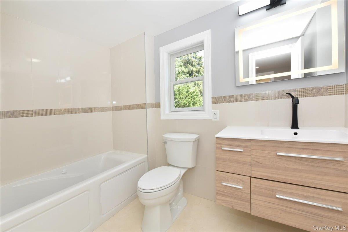 87 Dunlop Road Huntington, NY 11743 - Photo 22 of 31 a bathroom with a sink a toilet and bathtub