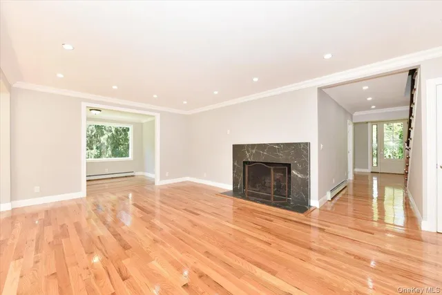 a view of empty room with wooden floor and fireplace