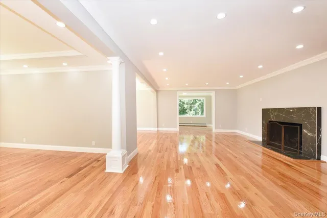 a view of empty room with wooden floor and fireplace