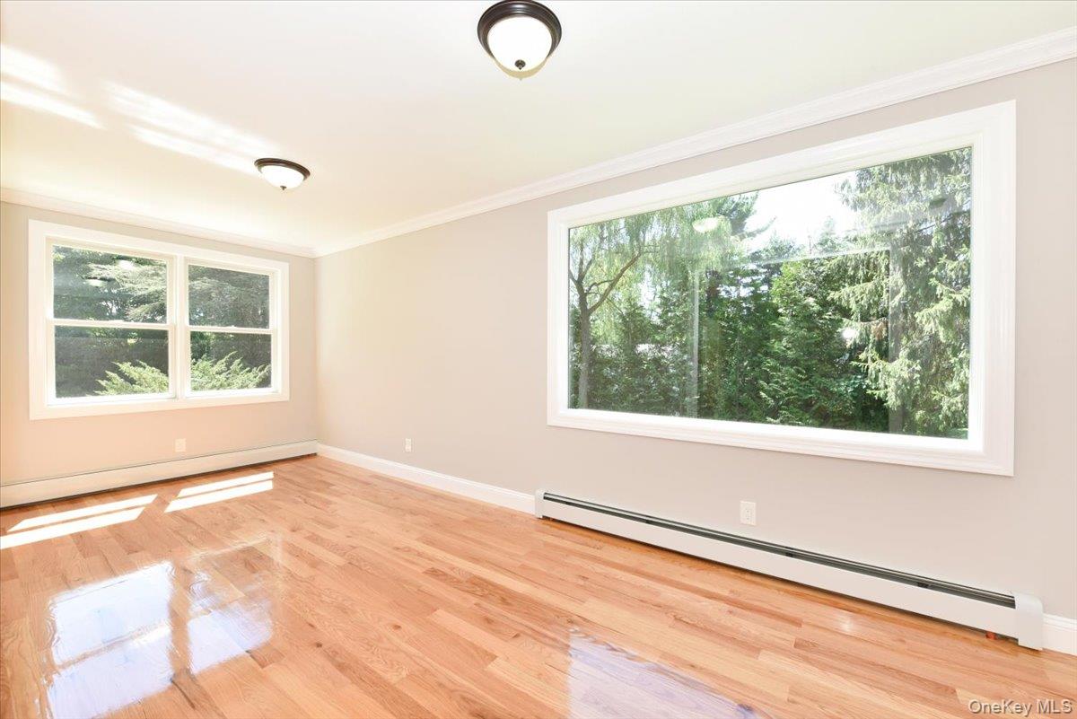 87 Dunlop Road Huntington, NY 11743 - Photo 7 of 31 a view of an empty room with a window and wooden floor