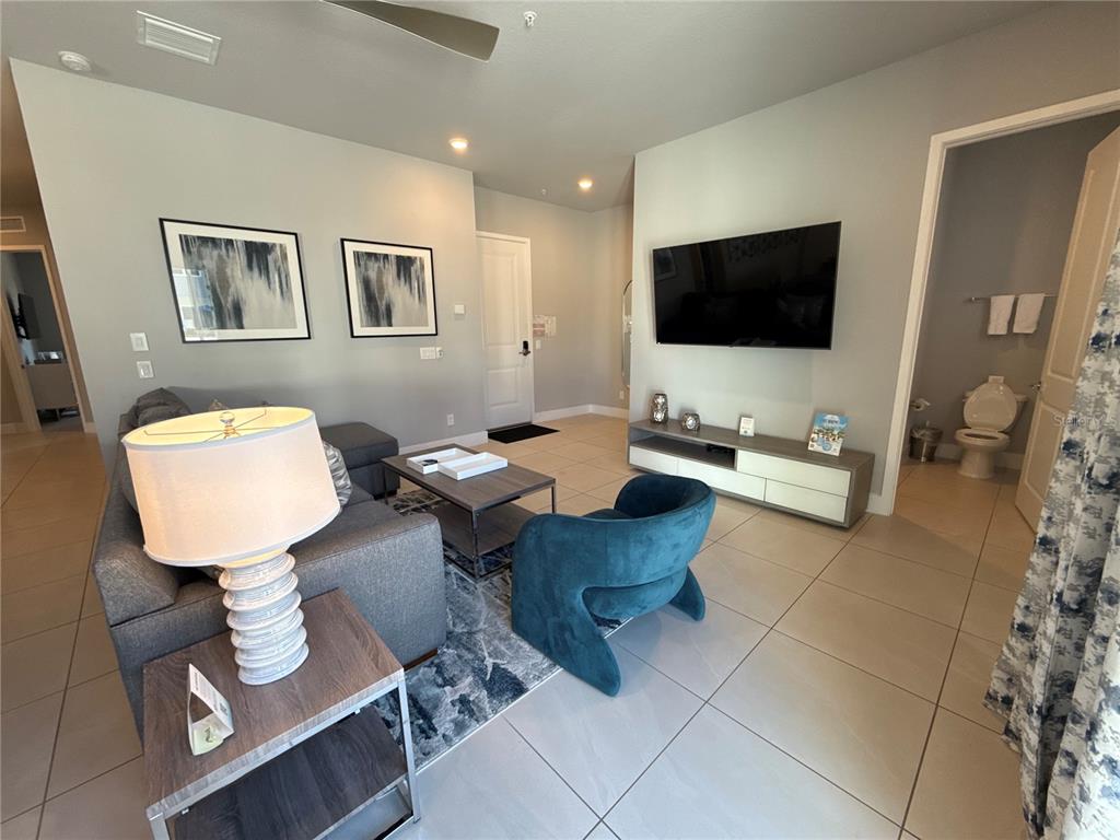 7740 Sandy Ridge Drive, Unit 120 Reunion, FL 34747 - Photo 9 of 36 a living room with furniture and a flat screen tv