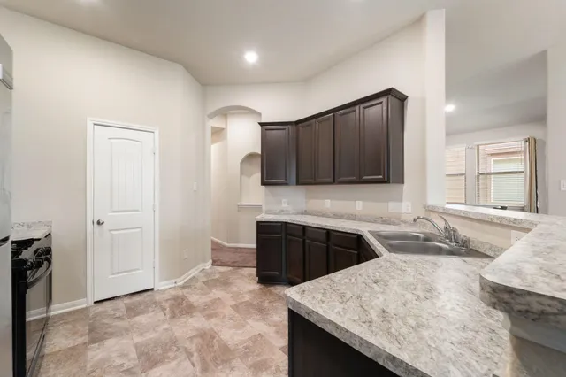 a kitchen with stainless steel appliances granite countertop wooden cabinets a stove top oven a sink and dishwasher