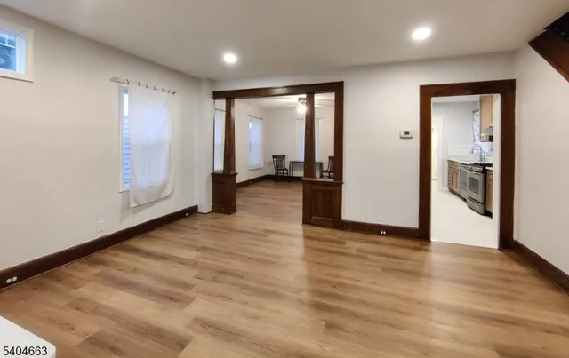 a view of an empty room with wooden floor and closet