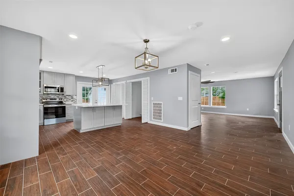 a view of a kitchen with cabinets and wooden floor