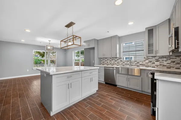 a kitchen with granite countertop a sink stainless steel appliances and cabinets